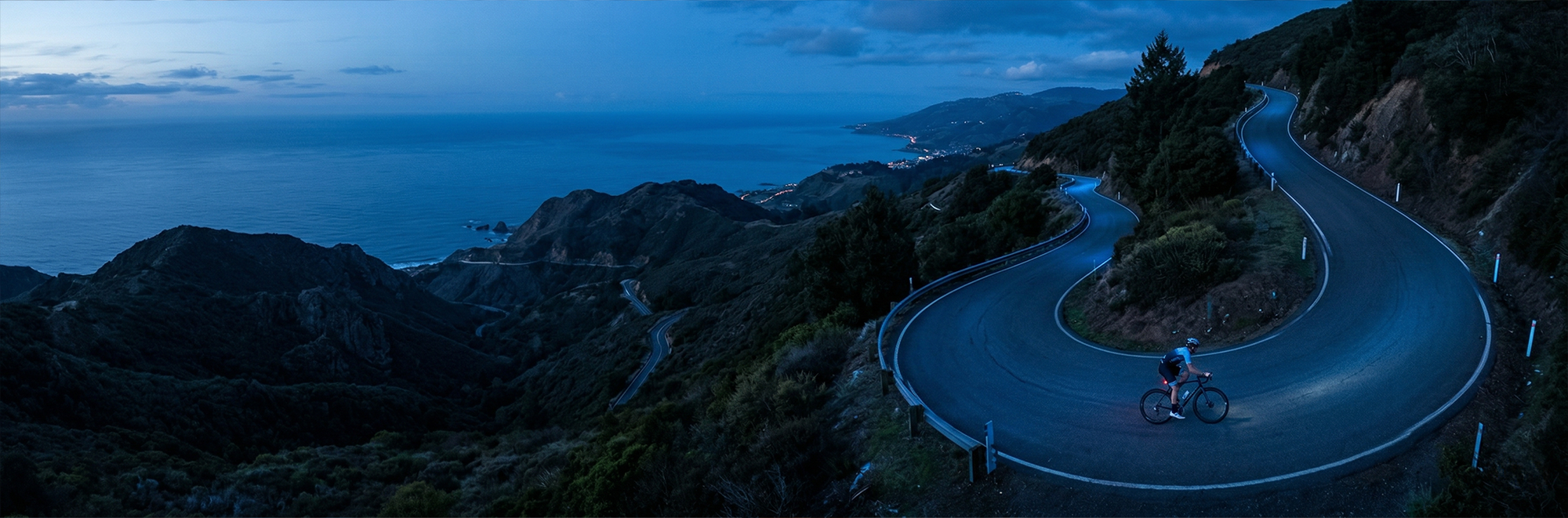 Cyclist riding uphill on a long windy road